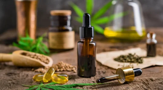 Une femme prend des gouttes de CBD au compte-gouttes dans sa cuisine.